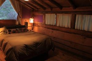 a bedroom with a bed in a log cabin at Mirador del Valle in Lago Puelo