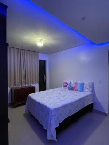 een slaapkamer met een groot bed met een blauw licht bij Cantinho Almeida in Alto Paraíso de Goiás