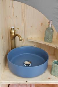 een blauwe wastafel met een kraan in de badkamer bij Bulle Ecureuil in Quarré-les-Tombes
