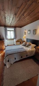 ein Schlafzimmer mit einem großen Bett und einer Holzdecke in der Unterkunft Casa do Patio - Très charmante villa 12 personnes 5ch avec piscine in São Bartolomeu + 70 Fotos