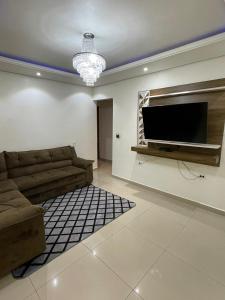 a living room with a couch and a flat screen tv at Cantinho Almeida in Alto Paraíso de Goiás
