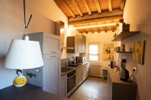 uma cozinha com armários brancos e um candeeiro no balcão em La finestra sulla Torre em Siena