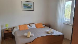 a bedroom with a bed with two towels on it at Apartments Irena in Božava