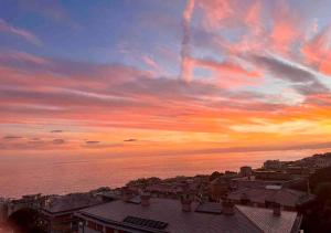 zachód słońca nad miastem z oceanem i budynkami w obiekcie Sunset Rooftop w Genui