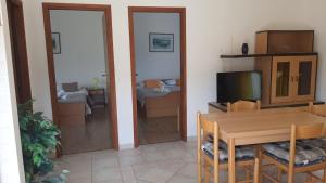 a living room with a dining room table and a television at Apartments Irena in Božava