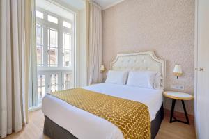 a hotel room with a bed and a window at Tandem Soho Suites in Málaga