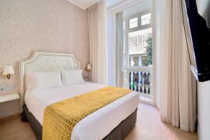 a bedroom with a bed and a window at Tandem Soho Suites in Málaga