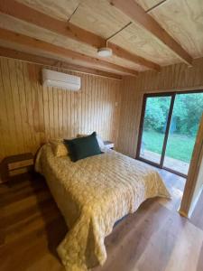a bed in a room with a large window at Tiny house los zorzales in Castro