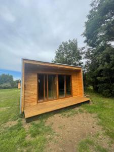 una pequeña casa de madera en un campo con árboles en Tiny house los zorzales en Castro