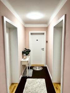 un couloir avec une porte blanche et une table blanche dans l'établissement SternenHimmel Gamlitz, à Gamlitz
