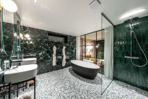y baño con bañera y lavamanos. en Hôtel Baud - Teritoria, en Bonne-sur-Ménoge