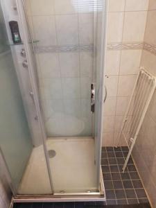 a shower with a glass door in a bathroom at Cosy studio apartment near by Ideapark in Lempäälä
