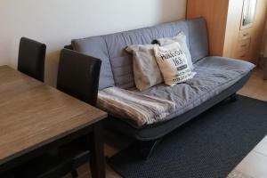 a couch with two pillows on it next to a table at Cosy studio apartment near by Ideapark in Lempäälä