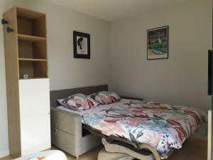 a bedroom with a bed with a comforter on it at La cabane au fond du jardin - 300m de la plage in Saint Malo