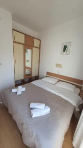 a bedroom with two beds with towels on them at Apartments Irena in Božava