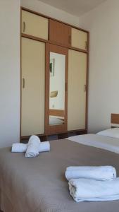 a bedroom with two beds and a large mirror at Apartments Irena in Božava
