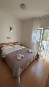 a bedroom with a large bed with towels on it at Apartments Irena in Božava