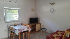 a room with a table and a television and a bed at Apartments Irena in Božava