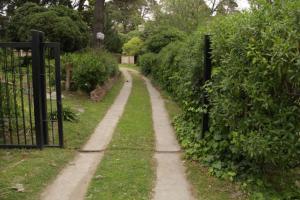un camino a través de un jardín con una valla en Pinamar departamento, edificio Atlántico en Pinamar