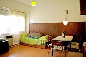 a bedroom with a bed and a table and chairs at Pinamar departamento, edificio Atlántico in Pinamar