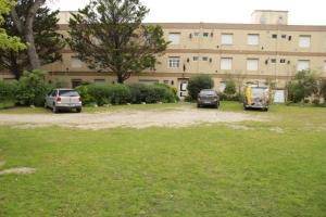 drie auto's geparkeerd op een parkeerplaats voor een gebouw bij Pinamar departamento, edificio Atlántico in Pinamar