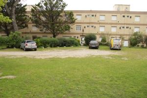 tres autos estacionados en un estacionamiento frente a un edificio en Pinamar departamento, edificio Atlántico en Pinamar