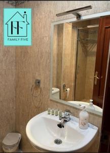 ein Badezimmer mit einem Waschbecken, einem Spiegel und einem WC in der Unterkunft FAMILY FIVE in Córdoba