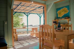 eine abgeschirmte Veranda mit einem Tisch und Stühlen in der Unterkunft Casa Madeira in Porto Novo