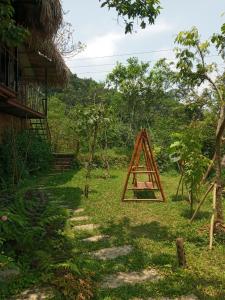 ein Dreieck im Gras neben einem Haus in der Unterkunft PuLuong BamBoo in Hương Bá Thước