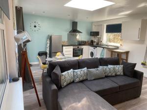sala de estar con sofá y cocina en The Wighthill, en Sandown