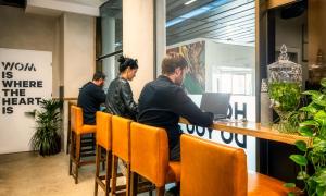 a group of people sitting at a table with a laptop at WOM Beach Pod Hotel - a member of Brown Hotels in Tel Aviv