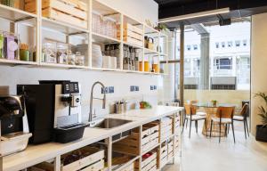 a kitchen with wooden cabinets and a sink and a table at WOM Beach Pod Hotel - a member of Brown Hotels in Tel Aviv