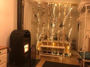 a living room with a fireplace and christmas lights at Larix Mátra Vendégház in Matraszentlaszlo