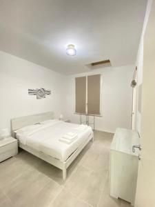 カザルマッジョーレにあるCastramajora Alloggiの白いベッドルーム(ベッド1台、シンク付)