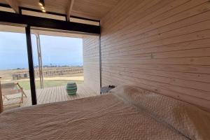 een slaapkamer met een muur met een bed en een raam bij Casa Blanca Fundo Duao in Iloca