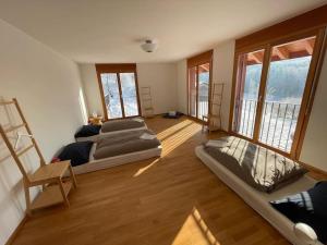 a room with three beds in a room with windows at Wunderschönes Gästehaus mit grandioser Aussicht in Gempen