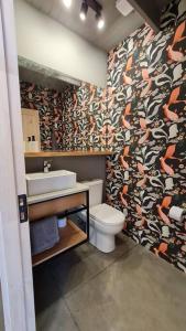 een badkamer met een toilet en een wastafel met behang bij Casa Blanca Fundo Duao in Iloca