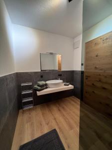 ein Bad mit einem Waschbecken und einem Spiegel in der Unterkunft Alp Apart Niederthai in Umhausen