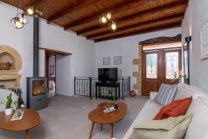 sala de estar con sofá blanco y chimenea en Alia Stone Villa-Ideal for families-Heated pool, en Nohia