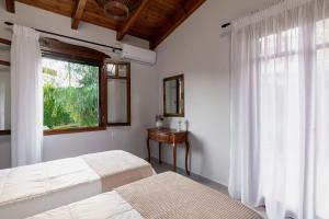 1 dormitorio con 2 camas y ventana en Alia Stone Villa-Ideal for families-Heated pool, en Nohia