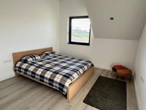 ein kleines Schlafzimmer mit einem Bett und einem Fenster in der Unterkunft Maison petite Suisse luxembourg in Berdorf