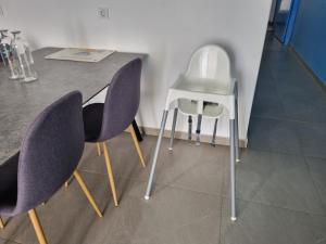 a table with purple chairs and a white stool at Appartement Cara do Mar in Praia