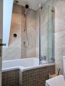 a bathroom with a shower and a bath tub at Chalet Brightstone Kingsdown Cliffs location with indoor pool, tennis court, mini-golf short walk to beach and 3 great local pubs in Kingsdown