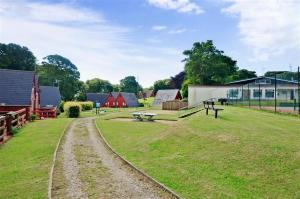 a grassy field with a building and a park at Chalet Brightstone Kingsdown Cliffs location with indoor pool, tennis court, mini-golf short walk to beach and 3 great local pubs in Kingsdown