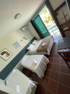 a small room with two beds and a window at Pousada Ponta Mar in Natal
