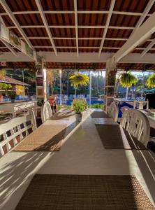 a dining room with tables and chairs and windows at Pousada Arraial do Ouro in Gaspar