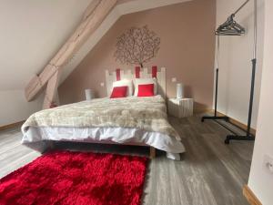 um quarto com uma cama com almofadas vermelhas e um tapete vermelho em Le cosy de la vologne em Gérardmer