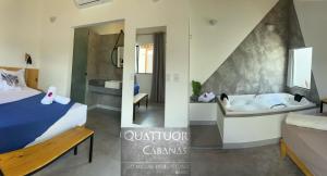 - une chambre et une salle de bains avec un lit et une baignoire dans l'établissement QUATTUOR Cabanas, à São Miguel do Gostoso