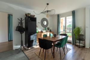 uma cozinha e sala de jantar com mesa e cadeiras em Appartement très calme, terrasse & jardin en ville em Besançon