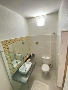 a bathroom with a toilet and a sink and a mirror at Hotel Encantos de Penedo Alagoas in Penedo